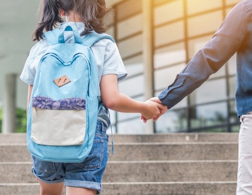 Genitore che accompagna la figlia a scuola.