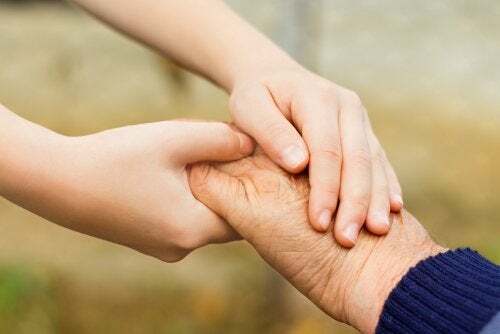 Adulti che rispettano i bambini. Bambino stringe la mano della nonna.