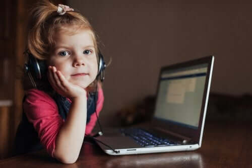 La teoria dell'esperienza dell'apprendimento bambina che studia al computer con delle cuffie.