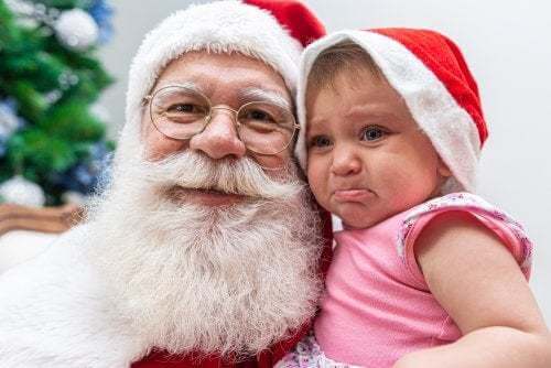 Bambina piange in braccio a Babbo Natale.