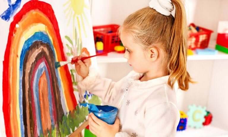 Bambina pittura con tempere e pennello