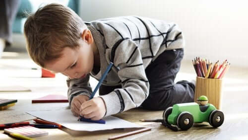 Bambino che disegna su un foglio con una matita