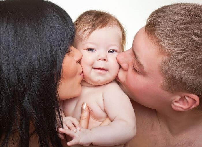 Genitori che baciano il figlio
