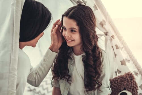 Mamma che offre attenzione positiva alla figlia con una carezza.