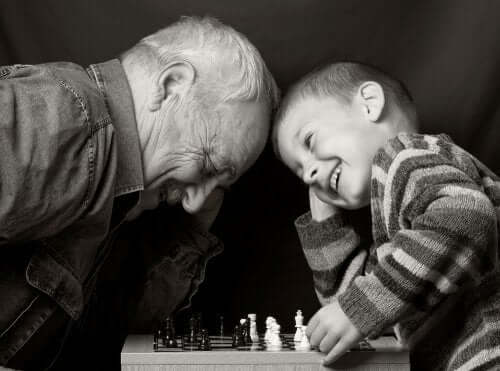 Nonno che gioca a scacchi col nipote felice