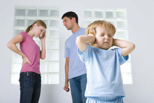 Aiutare il bambino durante il divorzio. Bambino che si tappa le orecchie perché i genitori litigano. 