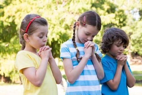 bambine e bambino che pregano