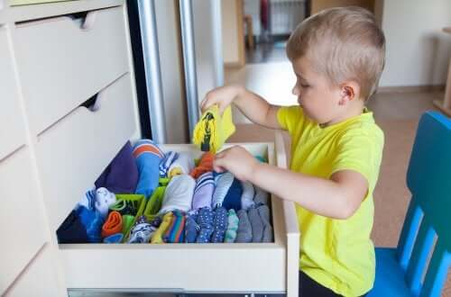 Bambino che mette in ordine il cassetto.