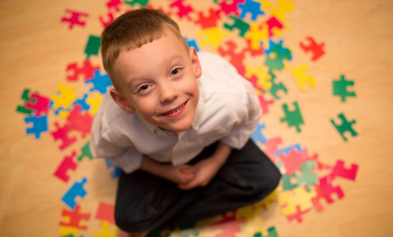 Bambino sorridente e pezzi di puzzle.