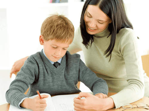 Bambino fa i compiti con la mamma. 