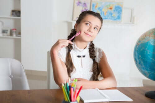 Bambina che pensa mentre studia