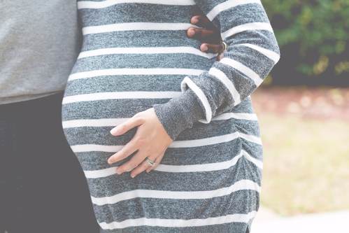 Donna in gravidanza con vestito grigio