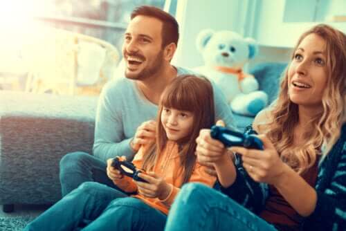Genitori che giocano alla play station con la figlia
