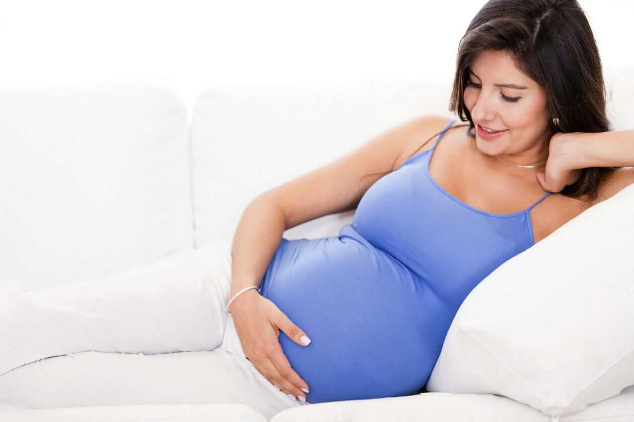 Donna incinta con top azzurro.