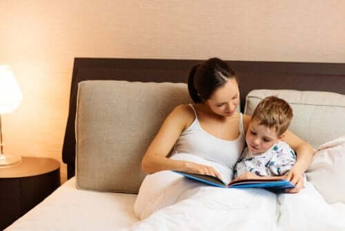 Avvicinare i bambini ai libri, madre e figlio leggono nel letto