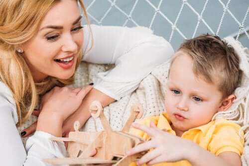 Bambino con giocattolo di legno e madre