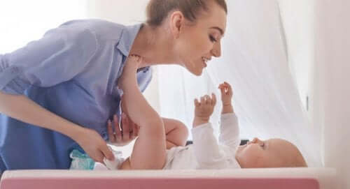 Mamma che cambia il pannolino al figlio