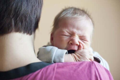 Neonato piange sulla spalla del padre