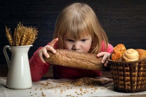 Bambina che guarda un pezzo di pane.