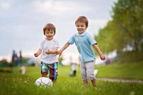 Bambini che giocano con la palla in un parco.