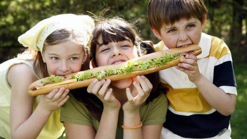 Bambini che condividono un panino gigante.