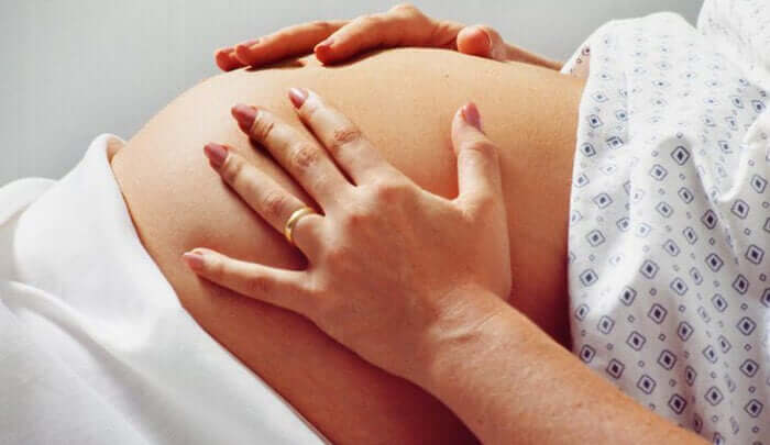 Donna incinta con le mani sulla pancia