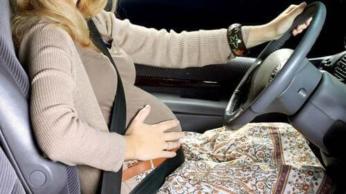 Guidare in gravidanza: donna guida col pancione.
