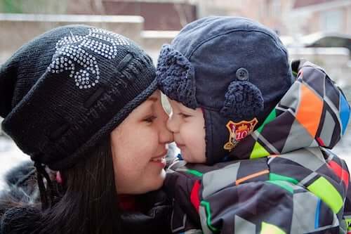 Figlio piccolo che bacia la mamma.
