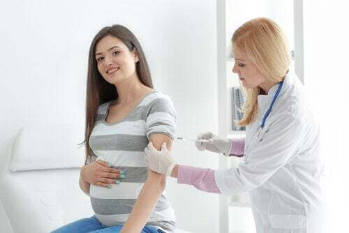 Donna viene visitata da una medica in gravidanza.