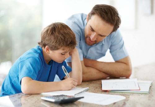 Padre che aiuta il figlio a fare i compiti: stili genitoriali.