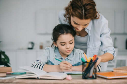 Bambina che fa i compiti con l'aiuto della mamma.