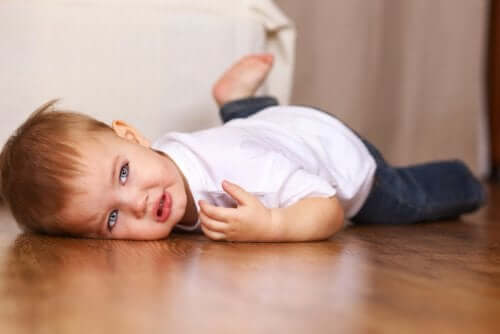 Bambino fa i capricci disteso sul pavimento