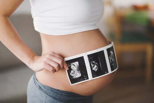 donna incinta che mostra un'ecografia