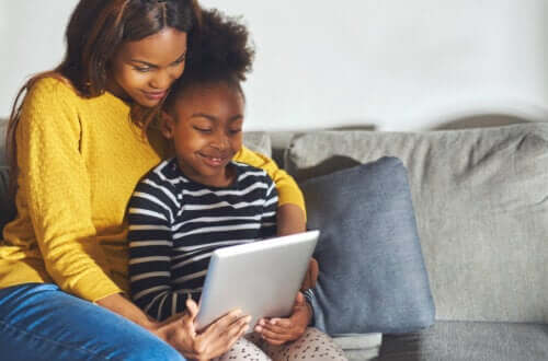 Mamma e figlia guardano qualcosa sul tablet. 
