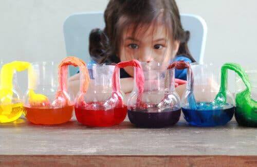 Bambina che gioca con acqua e colori