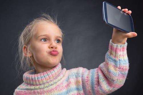 Bambina che si fa un selfie col telefono