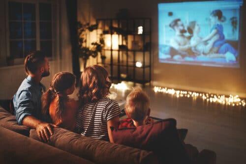 Famiglia seduta sul divano che vede un film per bambini