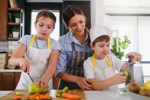 Madre e figli in cucina che preparano le verdure