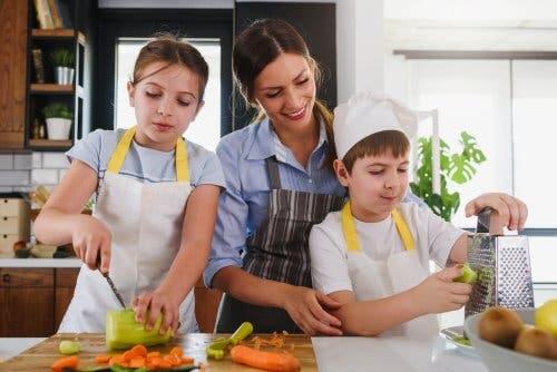 Madre e figli in cucina che preparano le verdure 