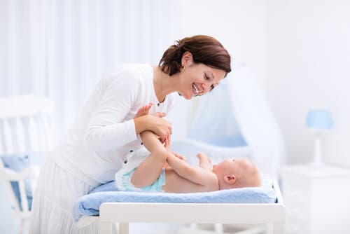 Mamma che cambia il neonato