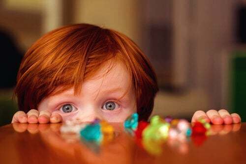 Bambino che fa capolino da un tavolo.