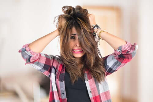 Donna nervosa che si tocca i capelli.