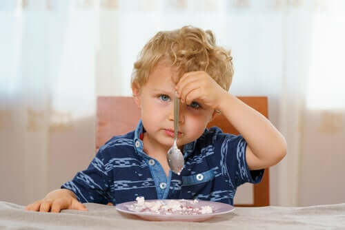 Bambino che tiene un cucchiaino con la mano sinistra.