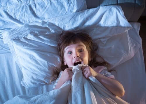 Bambina che si sveglia spaventata a causa di un incubo.