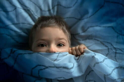 Bambino preoccupato sotto le coperte.