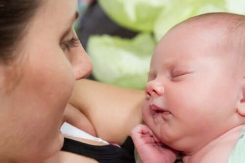 Neonato che dorme in braccio alla mamma.