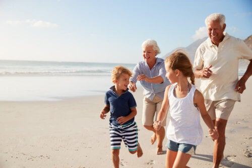 Nonni e nipoti che corrono felici in spiaggia in estate.