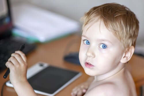 Bambino mancino che usa il tablet con la mano sinistra.