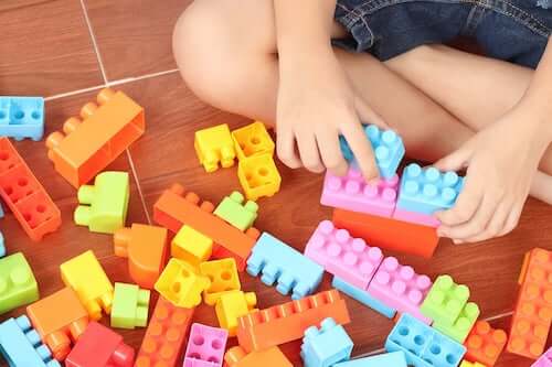 Bambino che gioca con pezzi colorati per costruzioni.