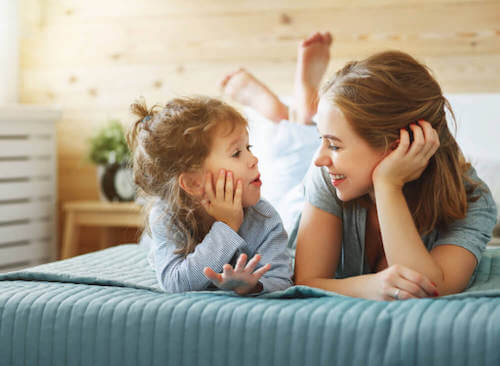 Ragazza e bambina parlano sul letto.